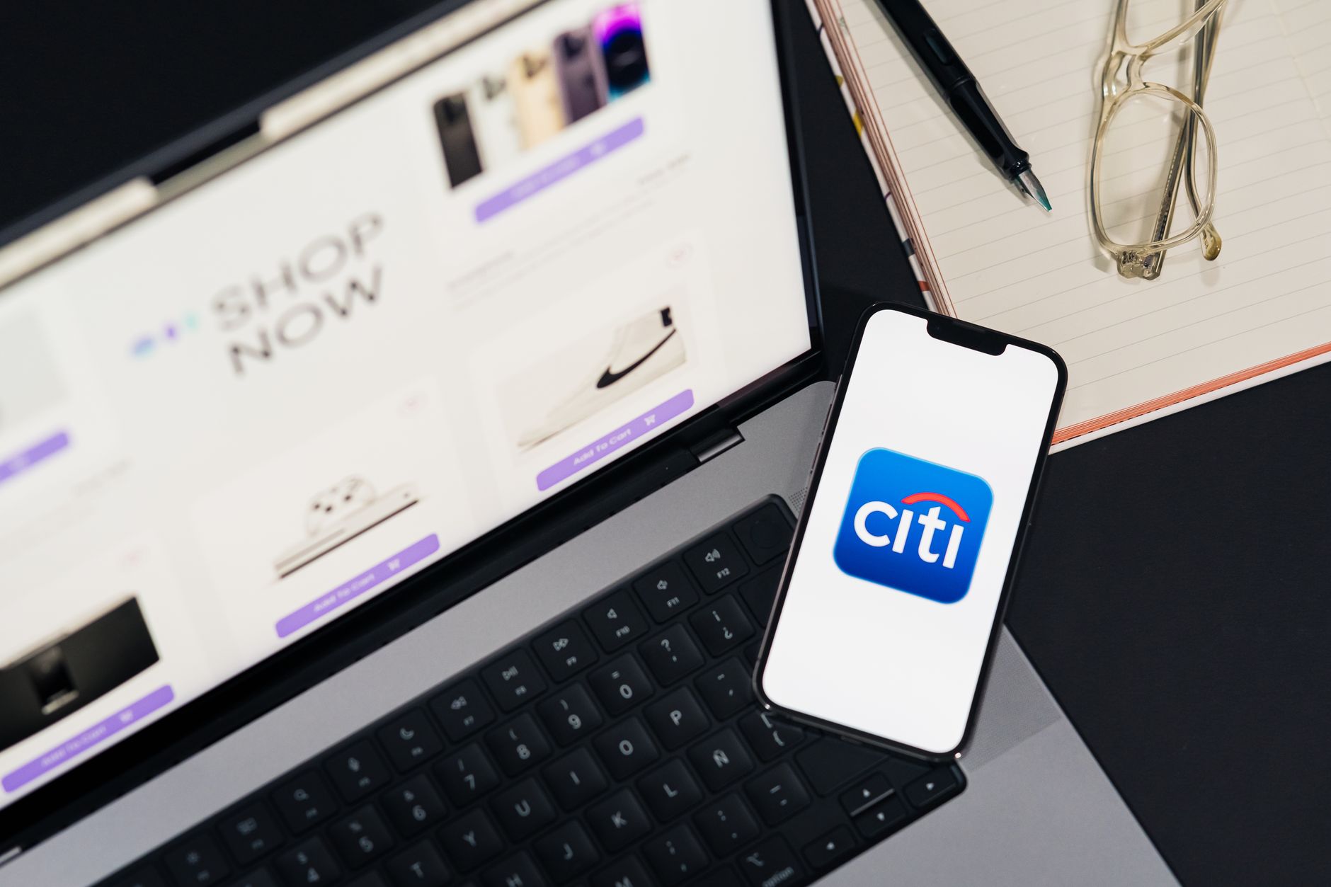 Ordinateur portable et smartphone présentant les achats en ligne et l'application de banque mobile Citi